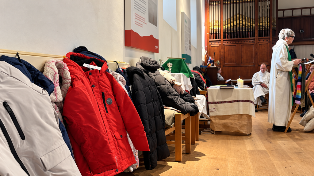 AI-generated illustration of winter coats lining the side of a church, with clergy and an organ in the background.