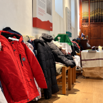 AI-generated illustration of winter coats lining the side of a church, with clergy and an organ in the background.